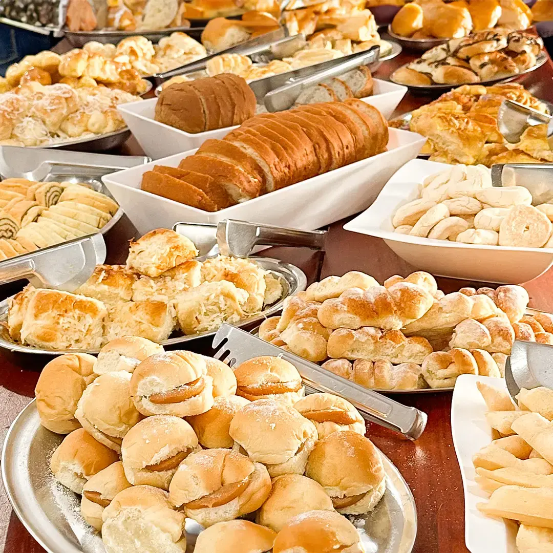 Bandejas de pães dourados recém-assados no bufê do café