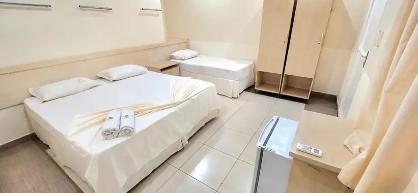 Suíte com cama de casal, cama de solteiro, frigobar e armário