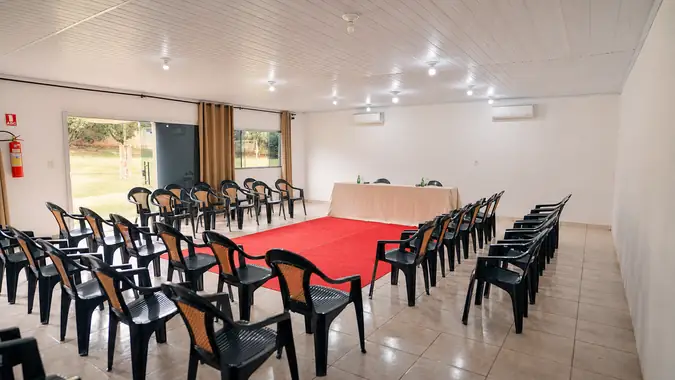 Sala pequena para oficinas, com cadeiras em torno do tapete vermelho