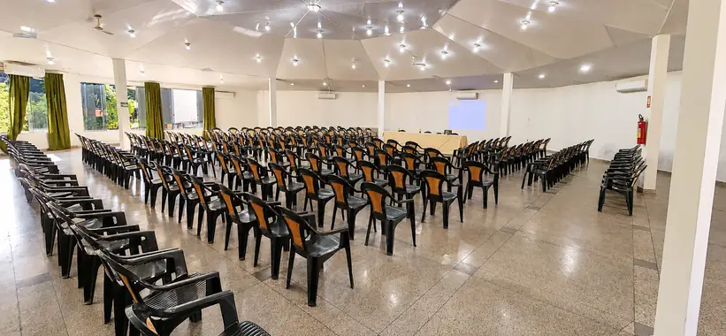 Fileiras de cadeiras do auditório Tucano voltadas para a tela de projeção