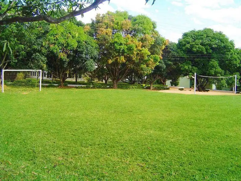 Campo de futebol de grama natural cercado de árvores